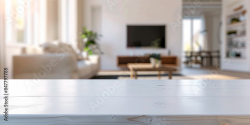 frontal view shot of empty white table in living room,  white blurred living room with tv and furniture in the background