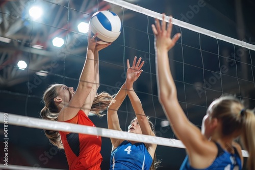 A close-up of intense volleyball match action, with players attempting to block at the net