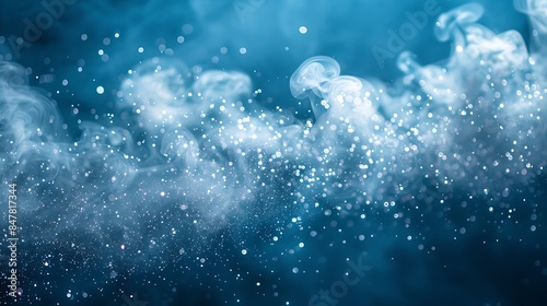 bright white particles creating a misty effect on a solid blue background © coco