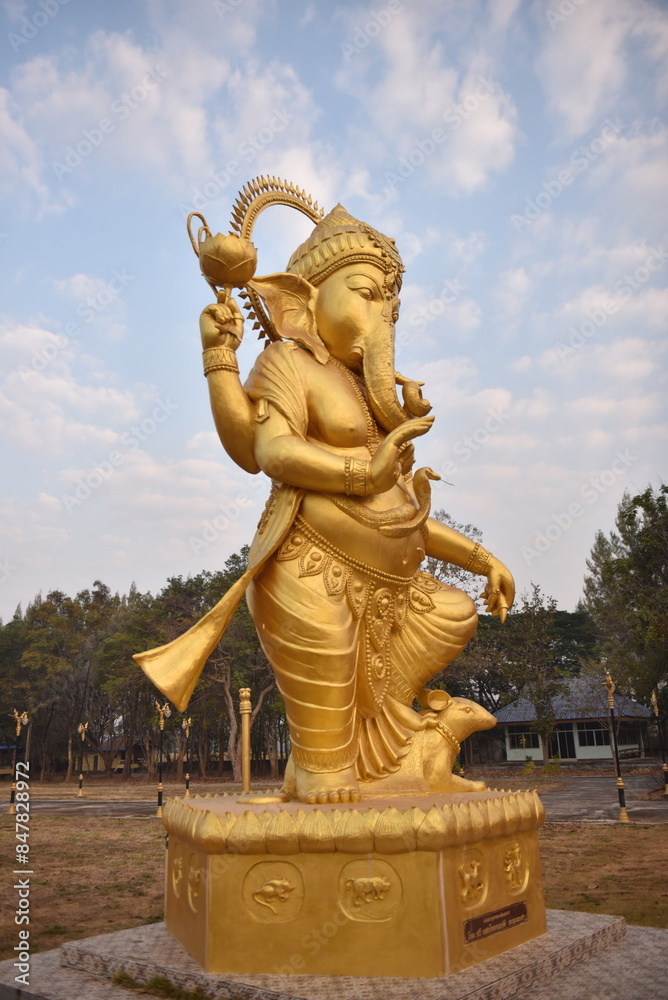 Obraz premium Statue of Lord Ganesha standing and giving blessings. A beautiful golden color rich in history and religion.