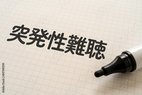 突発性難聴と書かれたノートとマーカー