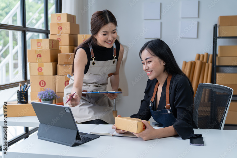 Starting small businesses SME Asians business owners, two check online orders Selling products working with boxes freelance work at home office marketing, packaging, concept Starting small businesses SME Asians business owners, two check online orders Selling products working with boxes freelance work at home office marketing, packaging, concept