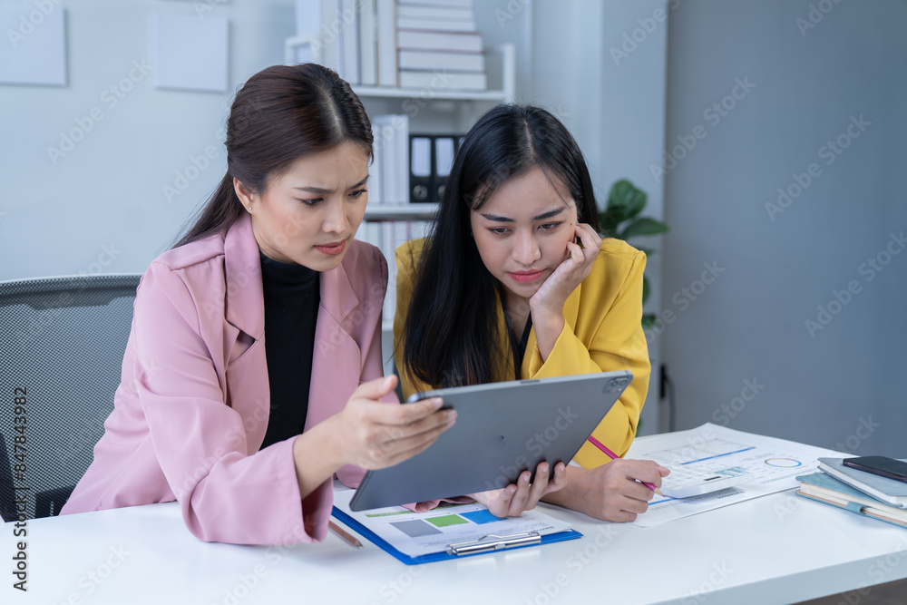 two women are while working on laptop and and consult for new project two women are while working on laptop and and consult for new project