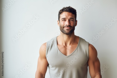 Portrait of a happy man in his 30s donning a trendy cropped top in front of minimalist or empty room background © CogniLens