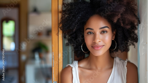 Smiling woman with curly hair standing by door at home Free Download Smiling woman with curly hair standing by door at home - GFXLoad