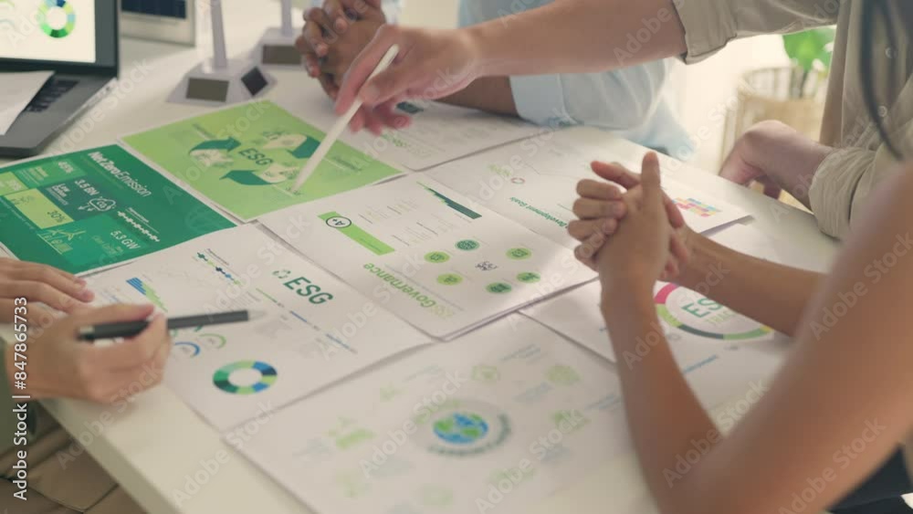 A close-up view of business professionals engaged in a strategy session, analyzing ESG (Environmental, Social, and Governance) performance metrics and sustainability strategies.