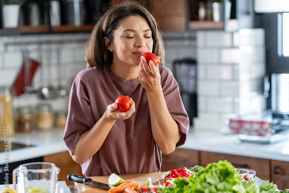 A young pretty cheerful woman is preparing a healthy various vegetable-based meal at home A young pretty cheerful woman is preparing a healthy various vegetable-based meal at home