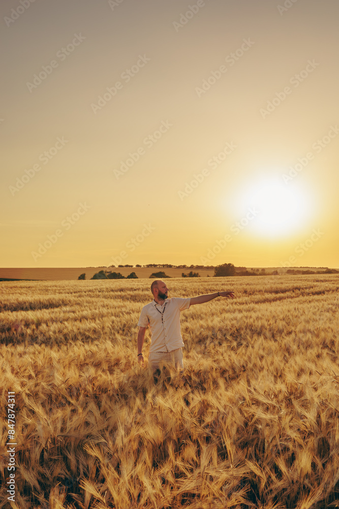 A man enjoys the sunset in a wheat field. A man enjoys the sunset in a wheat field.