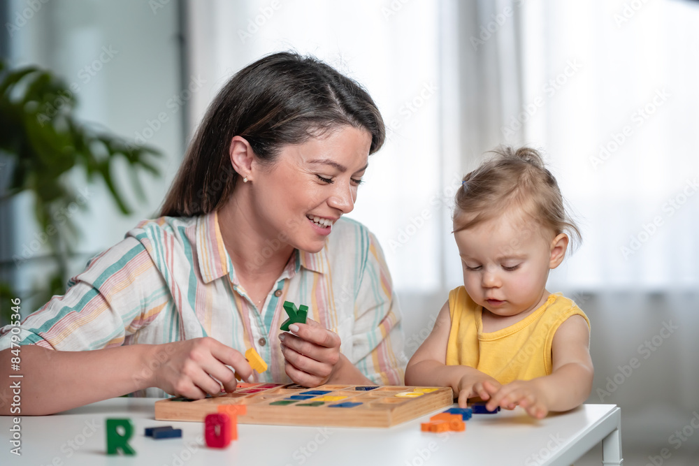 A young mother is playing with her young toddler daughter at home A young mother is playing with her young toddler daughter at home