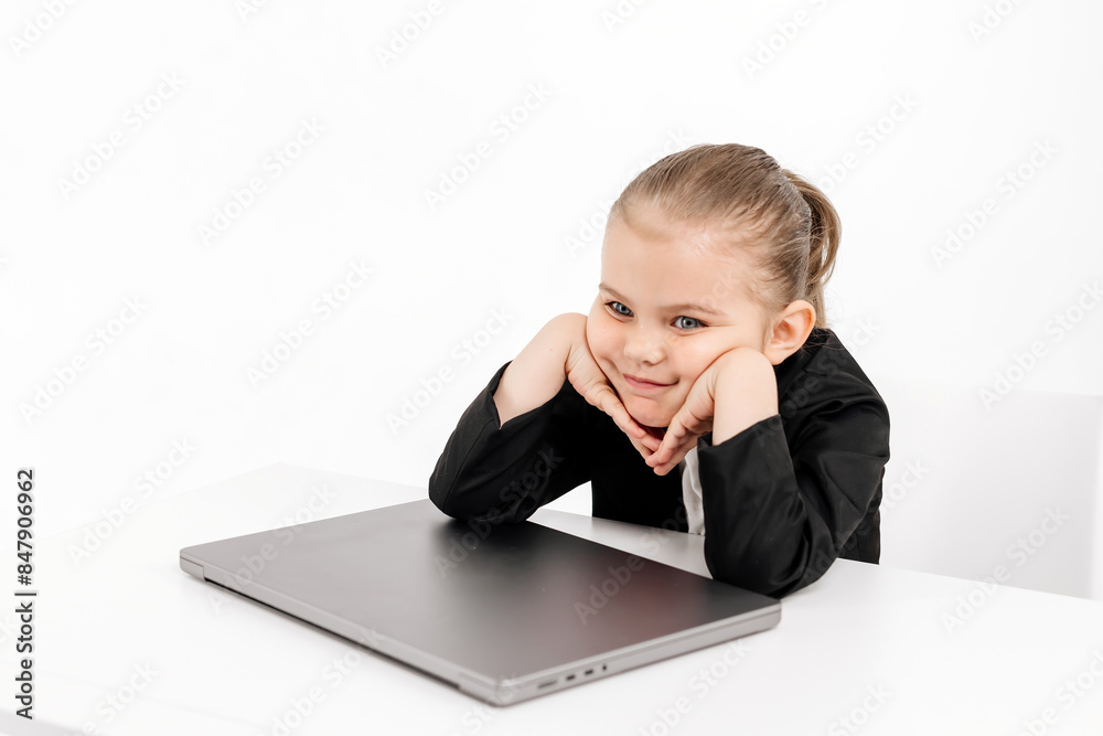 Close-up of a stylish business girl child studying at a laptop on an isolated white background. The concept of modern technology, business and education. Close-up of a stylish business girl child studying at a laptop on an isolated white background. The concept of modern technology, business and education.