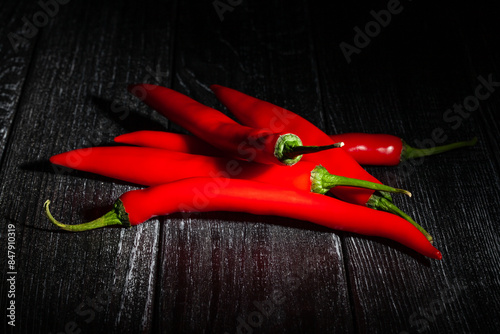 long chili pepper on black wood background
