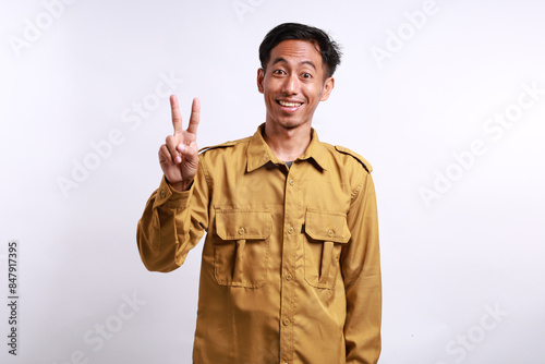 Enthusiastic Indonesian government employees standing while showing two fingers. Isolated on white photo