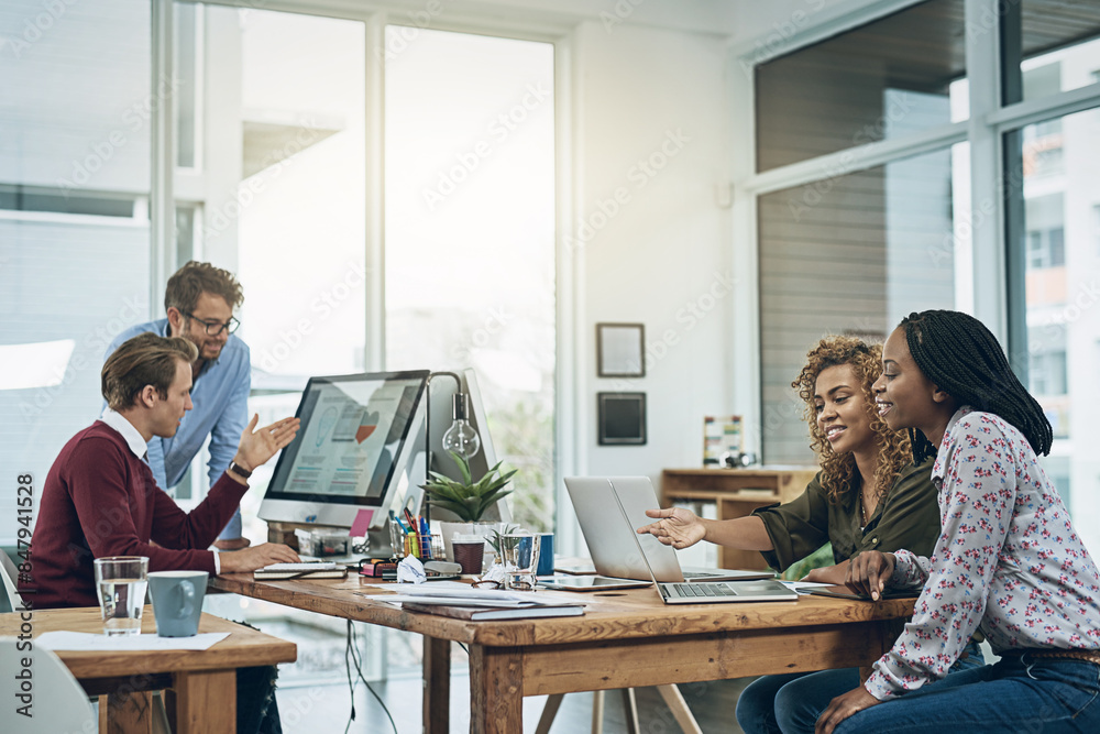 © peopleimages.com - Teamwork, computer and business people at desk in coworking space for discussion, planning project or feedback. Lens flare, diversity and staff at design agency for collaboration, review or report
