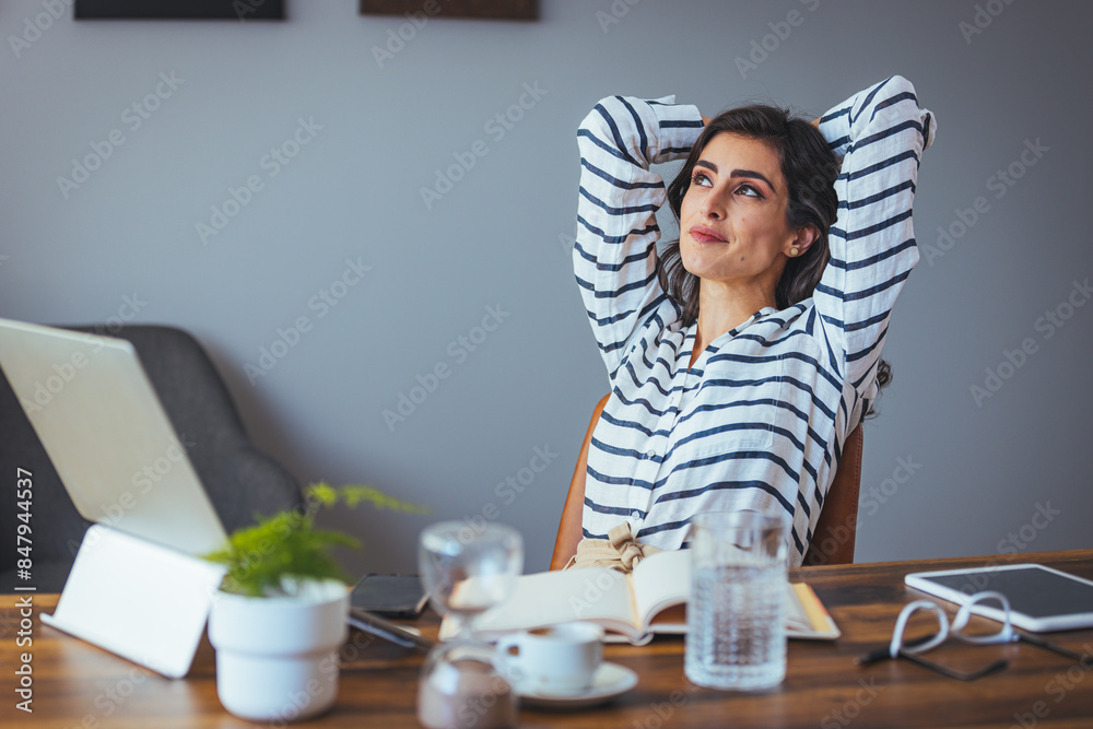 A professional woman looks thoughtfully away from her laptop, flexing her arms behind her head, surrounded by office essentials on a sleek desk. A professional woman looks thoughtfully away from her laptop, flexing her arms behind her head, surrounded by office essentials on a sleek desk.
