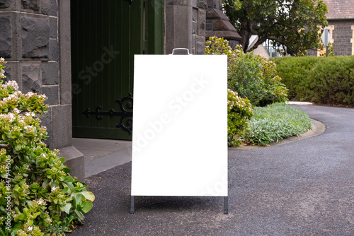 Background texture of a blank white mockup board outside a historic church building. Empty template of A-Frame standing easel sign. Copy space for design. photo