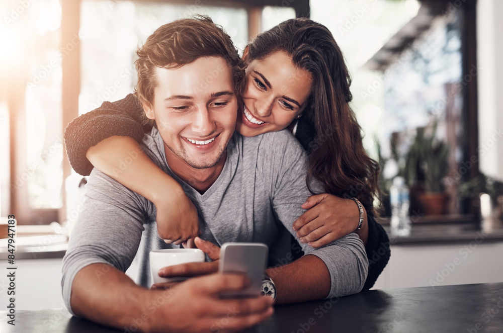 Happy, couple and hug with phone in kitchen for communication, website or scroll on social media. Man, woman and love with tech in morning for post, notification or online relationship update at home Happy, couple and hug with phone in kitchen for communication, website or scroll on social media. Man, woman and love with tech in morning for post, notification or online relationship update at home