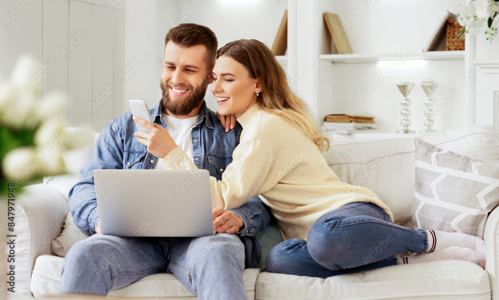 Surfing Internet. Young Couple Relaxing With Laptop And Smartphone, Sitting On Sofa Surfing Internet. Young Couple Relaxing With Laptop And Smartphone, Sitting On Sofa