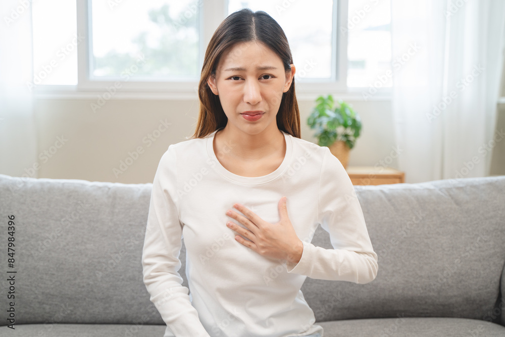 Acid reflux disease, suffer asian young woman have symptom gastroesophageal, esophageal, stomach ache and heartburn pain hand on chest from digestion problem after eat food, Healthcare medical concept Acid reflux disease, suffer asian young woman have symptom gastroesophageal, esophageal, stomach ache and heartburn pain hand on chest from digestion problem after eat food, Healthcare medical concept