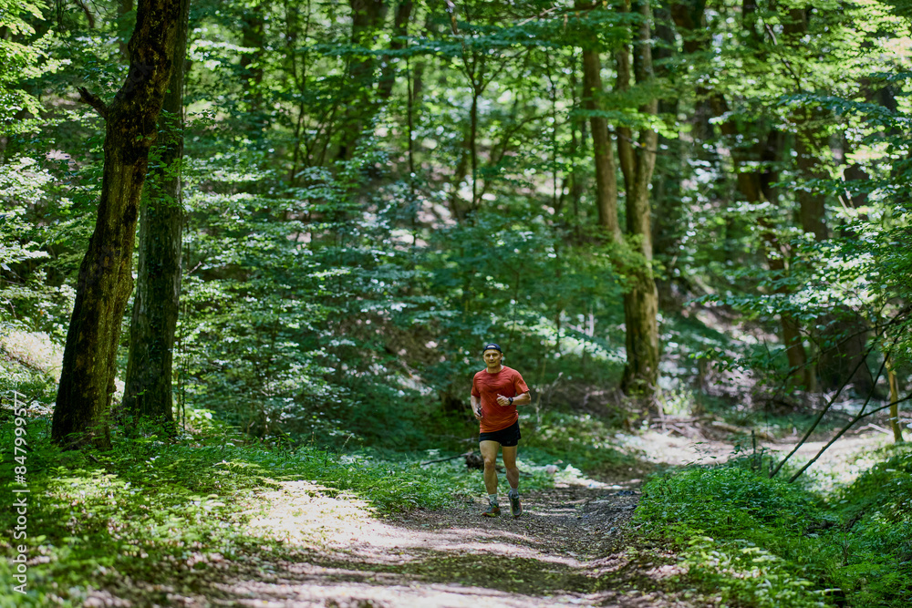 Fototapeta premium a strong middle-aged man running through the forest