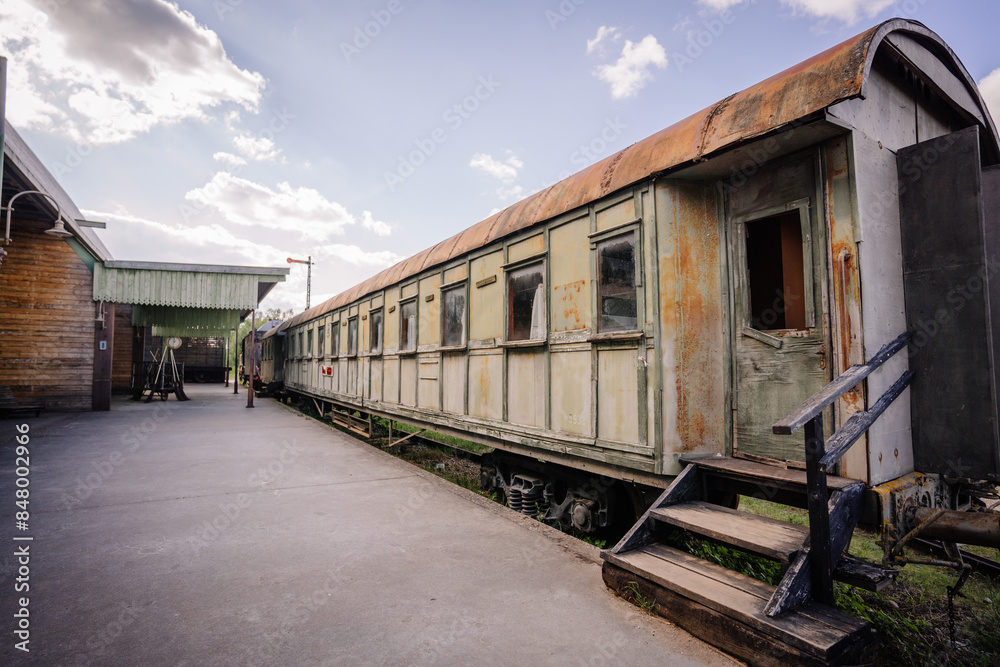 Dobele, Latvia - June 7, 2024 - A rusted, abandoned train carriage at an old station platform on a sunny day, capturing the essence of decay and nostalgia. Dobele, Latvia - June 7, 2024 - A rusted, abandoned train carriage at an old station platform on a sunny day, capturing the essence of decay and nostalgia.