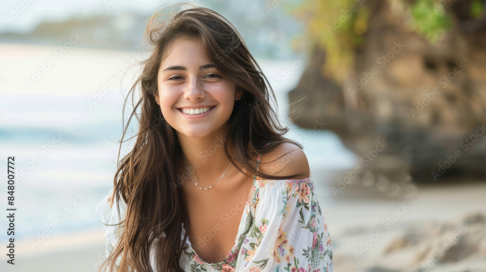 Smiling young woman sitting on the beach in summer Smiling young woman sitting on the beach in summer