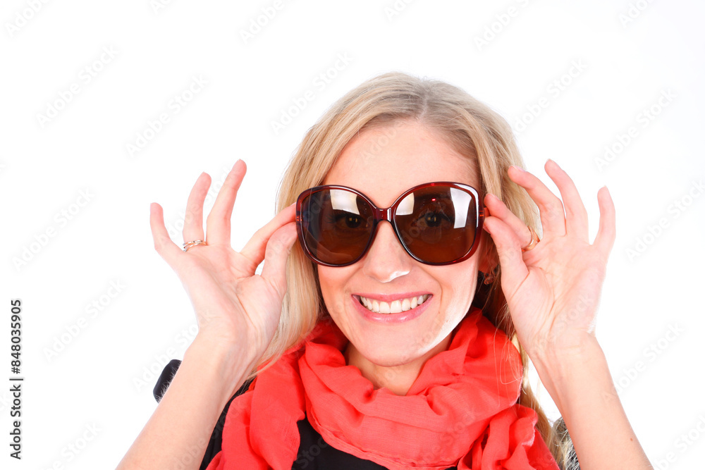A blonde woman with a wide smile tries on fashionable sunglasses A blonde woman with a wide smile tries on fashionable sunglasses