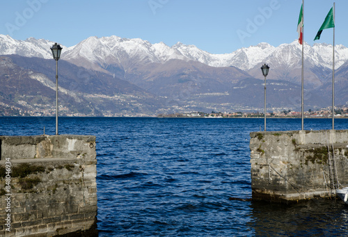 Harbour on an Alpine Lake Como with Snow Capped Mountain in a Sunny Day in Lombardy, Italy. photo