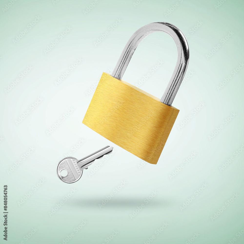 Padlock and key in air on light turquoise background Padlock and key in air on light turquoise background
