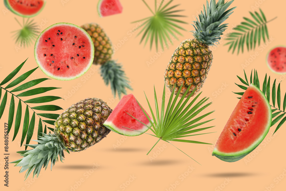 Fototapeta premium Summer party. Tropical fruits and palm leaves in air on peach color background