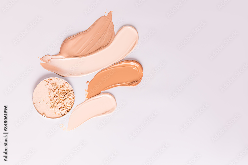 several chic samples of foundation powder , a round block of compact powder on a beige background. texture samples for product advertising