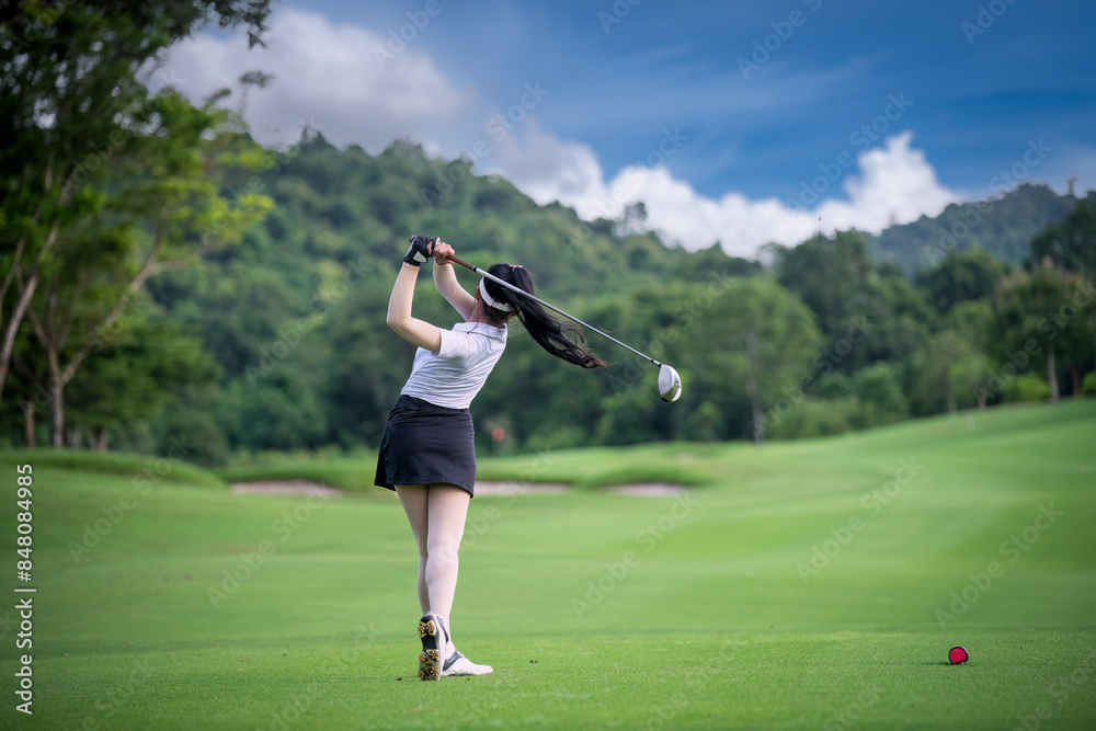 Professional woman golfer teeing golf in golf tournament competition at golf course for winner Professional woman golfer teeing golf in golf tournament competition at golf course for winner