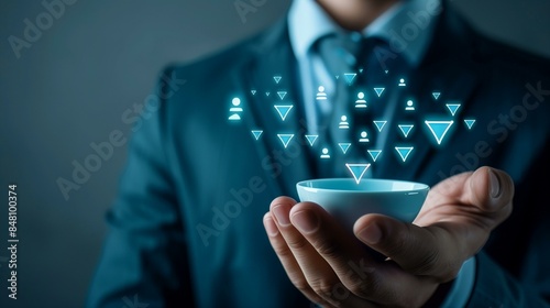 Businessman in suit holding bowl with glowing blue human icons rising from symbolizing lead generation recruitment talent acquisition, employment employee candidate photo