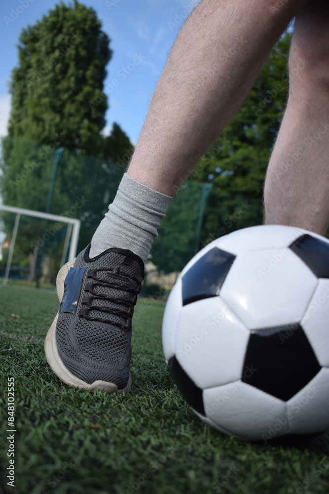 A young man in sportswear is playing soccer, training on a football pitch in the morning. Dedication and passion for the sport, the essence of morning exercise and practice outdoors A young man in sportswear is playing soccer, training on a football pitch in the morning. Dedication and passion for the sport, the essence of morning exercise and practice outdoors