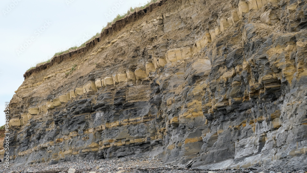 View of cliff with layers of different coloured rocks at popular fossil hunting destination of Kilve Beach on the Jurassic Coast in England UK View of cliff with layers of different coloured rocks at popular fossil hunting destination of Kilve Beach on the Jurassic Coast in England UK