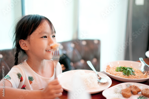 Cute asian girl eating Chicken Nugget by self. Background. Copy space.	
