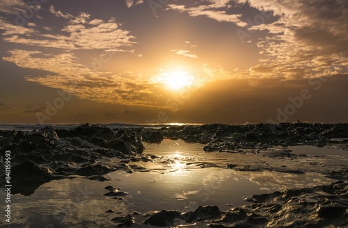 Scenic view of golden sunset over a rocky shoreline