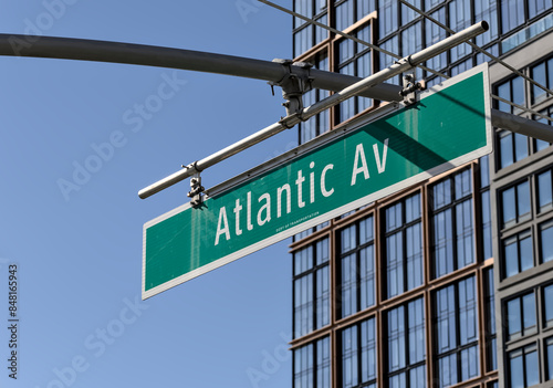 Atlantic avenue sign on street light traffic light lamp post in brooklyn, ny (av ave new york city) with modern apartment building background lightpost streetlight downtown heights pier bridge park photo