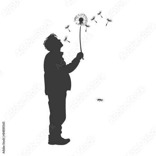 Silhouette of boy blowing dandelion seeds, wishful thinking concept.