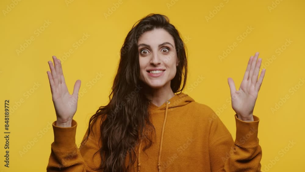Surprised Woman with Hands Raised on Yellow Background Surprised Woman with Hands Raised on Yellow Background