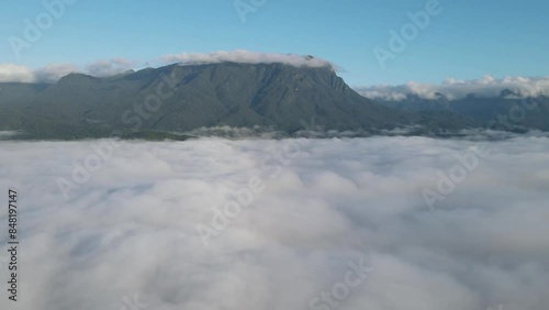 Voo sobre mata atlântica com pico Marumbi ao fundo na região de Morretes no Paraná sobre mar de nuvens ao amanhecer photo