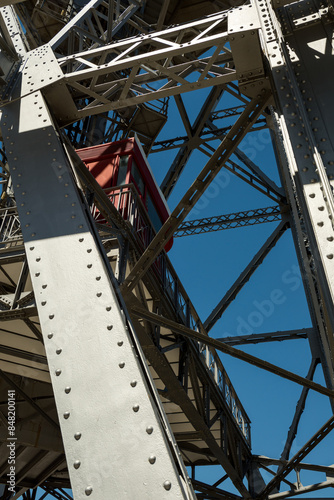 Shot of exterior detail of vintage steel girder structure supporting a tower. 