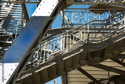 Shot of exterior detail of vintage steel girder structure supporting a tower. 