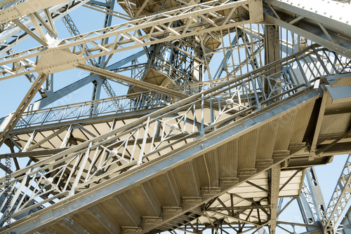 Shot of exterior detail of vintage steel girder structure supporting a tower. 