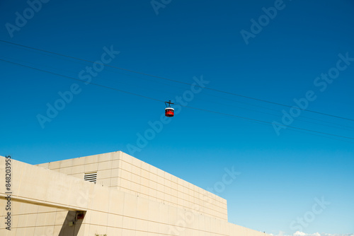 Red funicular cars against blue skies. 