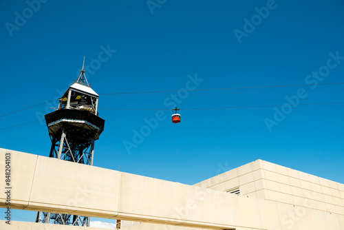 A funicular tower with red funicular cars against blue skies. 