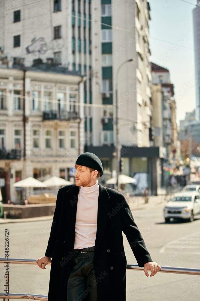 Red-haired man in debonair black coat and hat leaning on rail. Red-haired man in debonair black coat and hat leaning on rail.