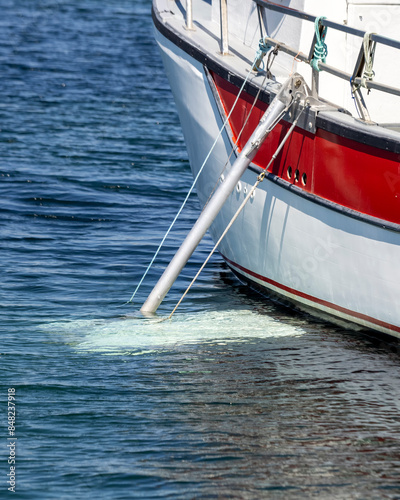 Fishing boat with an aluminium stabilizer deployed.