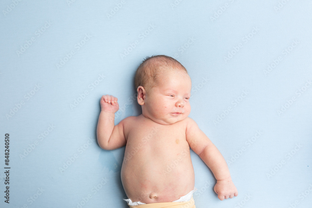 newborn baby lies on a blue background. portrait of a little boy newborn baby lies on a blue background. portrait of a little boy