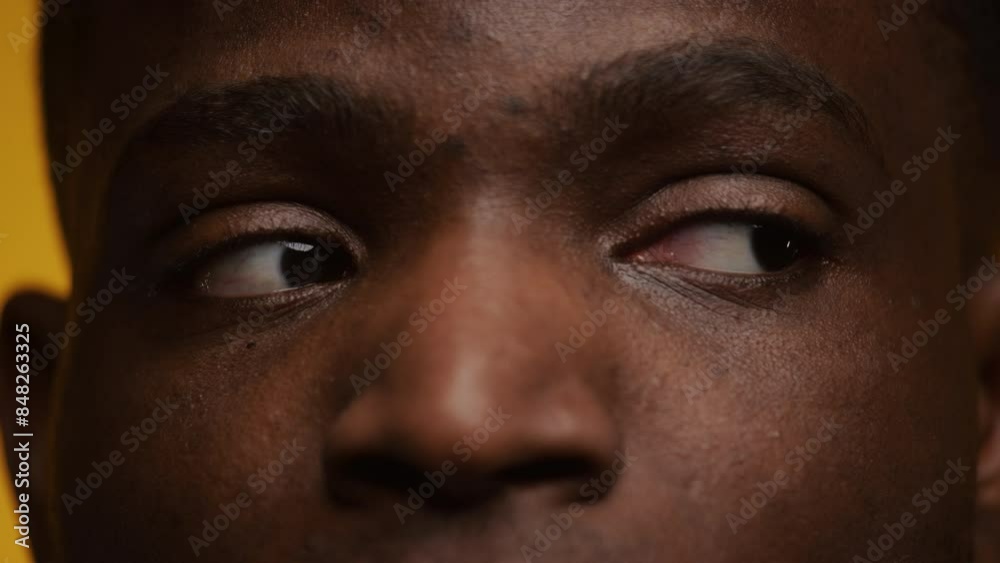 Close-Up of a Man Eyes Looking to the Side on Yellow Close-Up of a Man Eyes Looking to the Side on Yellow