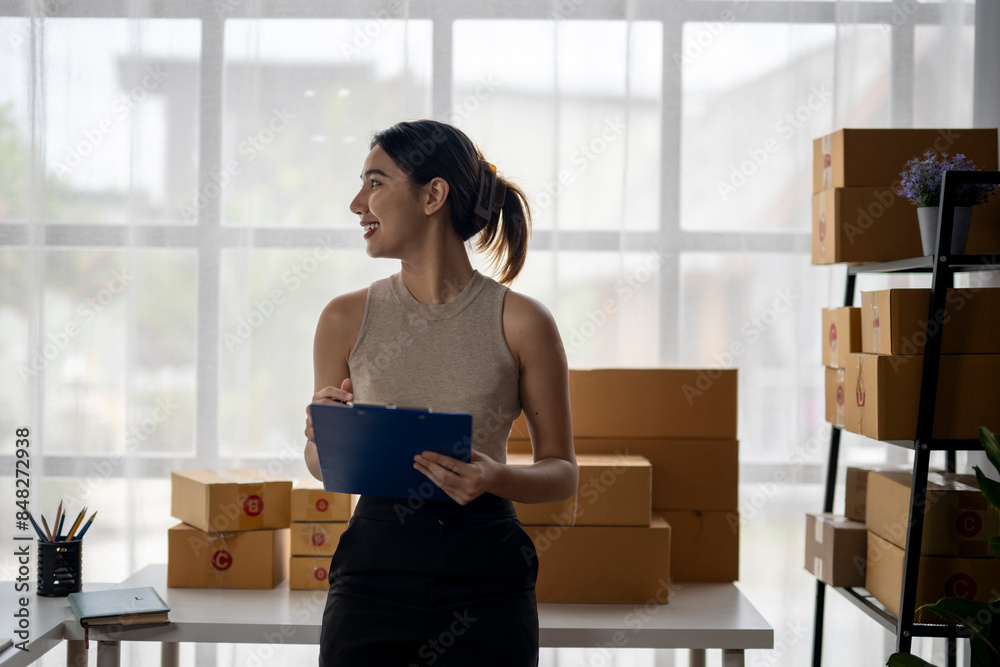 A woman is standing in front of a stack of boxes with a clipboard in her hand A woman is standing in front of a stack of boxes with a clipboard in her hand